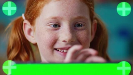 Closeup of a young smiling redhead girl with pigtails looking directly at the camera with a happy expression framed by green digital interface elements suggesting an interactive or augmented reality . - Powered by Adobe