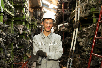 Technician worker working and smile to the camera in garage scrap yard car workshop warehouse.
