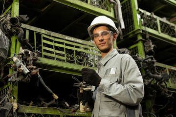 Technician worker working and smile to the camera in garage scrap yard car workshop warehouse.
