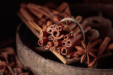 Cinnamon sticks, anise, and nutmeg on a wooden table.