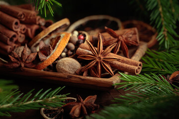 Spices and branches of Christmas tree on an old wooden table.