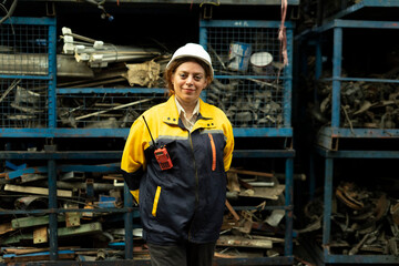 Portrait of technician women worker stand, looking camera happy smiling in garage scrap yard car workshop warehouse.