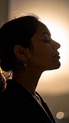 Silhouette portrait of a woman, contemplative mood in backlight, golden hour photography