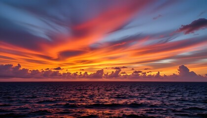 Naklejka premium Vibrant Sunset Over Ocean Waters with Dramatic Cloudscape and Multicolored Sky