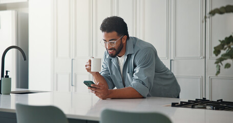 Phone, coffee and man in kitchen in home with networking, communication or social media on mobile app. Tea, technology and male person with cellphone for contact, texting or chatting in apartment.