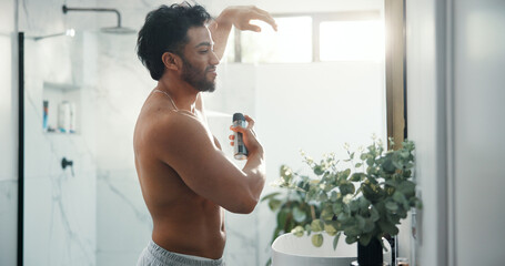 Man, spray armpit and bathroom mirror in home with smile, fragrance and flare with morning routine. Person, grooming and self care with deodorant for odor, sweat or happy with bottle at apartment