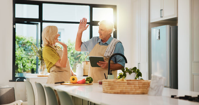 Senior couple, high five and tablet for cooking in kitchen, recipe and excited for teamwork at house. People, vegetables and ingredients with tech, app or success for nutrition in retirement home