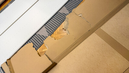 Cardboard chaos on parquet floor resembles abstract metropolis, echoing Earth Day's call for recycling epiphanies and green innovation