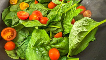 Rustic spinach and cherry tomato medley heralds equinox harvest tranquility, aligning with World Vegetarian Day festivities