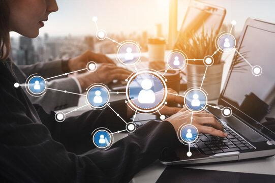 A team of professionals collaborates in a modern office setting, using laptops to connect digitally. Network icons symbolize teamwork and communication. Tessel - Powered by Adobe