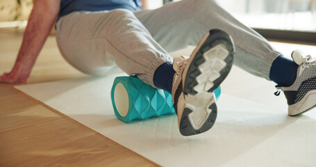 Legs, stretching and man with foam roller, physical therapy and muscle recovery with wellness. Health facility, person and patient with exercise, mobility training or rehabilitation with healing