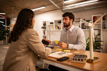 Colleagues discussing renewable energy project in office