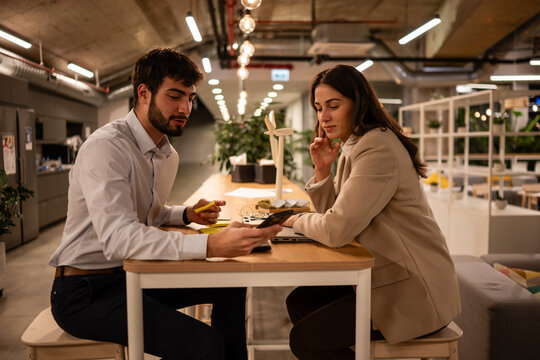 Business professionals collaborating at office meeting reviewing smartphone