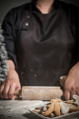 Female making festive Christmas gingerbread cookies in the home kitchen