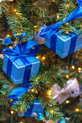 Christmas tree decorated with blue gift boxes and ribbons.