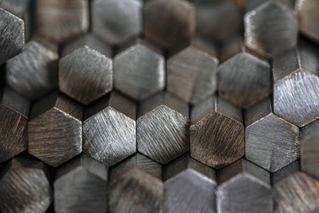 Stack of shiny nonferrous metal rods stored in industrial factory warehouse, close-up view