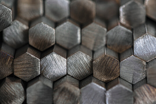 Stack of shiny nonferrous metal rods stored in industrial factory warehouse, close-up view