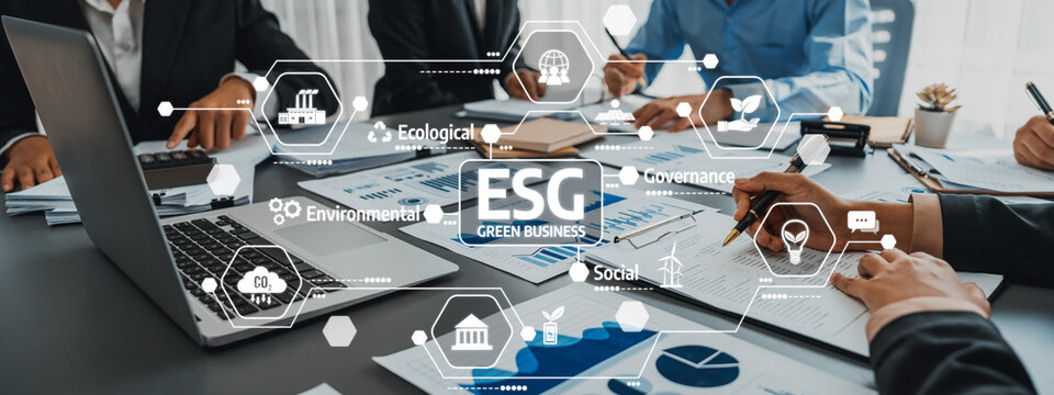 A diverse business team collaborates on environmental, social, and governance strategies, utilizing digital infographics and data presentations in a modern office setting. Amity