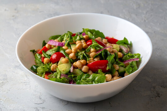 Vegetarian chickpea salad with tomatoes, arugula, parsley, spinach and red onion. Healthy food, diet. Top view