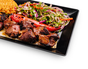 Grilled meat platter with rice and fresh salad served at a dining table