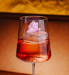 Refreshing cocktail with flower garnish served in elegant glass