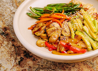 Colorful mix of sauteed vegetables on a neutral plate in a kitchen setting