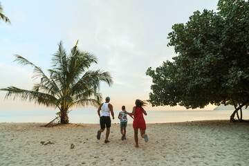A happy time in the life of a family is an evening fun walk along the beach in Thailand.