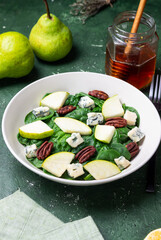 Salad with spinach, blue cheese, pear, and nuts. Healthy eating. Vegetarian food.