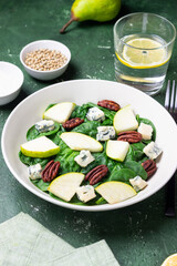 Salad with spinach, blue cheese, pear, and nuts. Healthy eating. Vegetarian food.