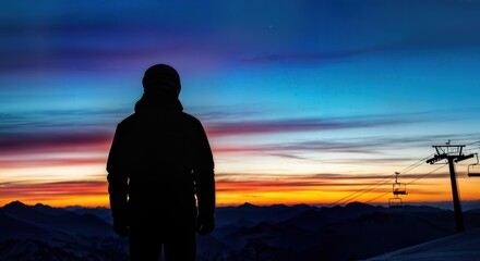 Solitary silhouette figure on ski slope at blue hour twilight with colorful sky gradient and mountain horizon winter scene