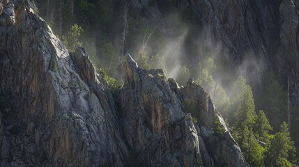 Rocky mountain peaks, sunlit with mist and forest, in a rugged landscape, close - up view, copy space