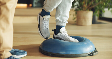 Feet, person and balance on ball for physiotherapy at house with assistance for mobility training....