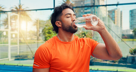 Padel, drinking water and man with fitness, relax and training with break, hydration and aqua....