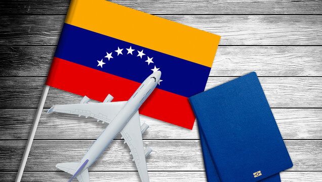 Flag of Venezuela with passport and toy airplane on wooden background. Flight travel concept  - Powered by Adobe