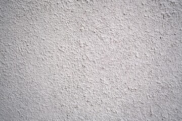 Close-up of a white plaster wall with a coarse, gritty texture, commonly used in exterior or interior architectural finishes.

