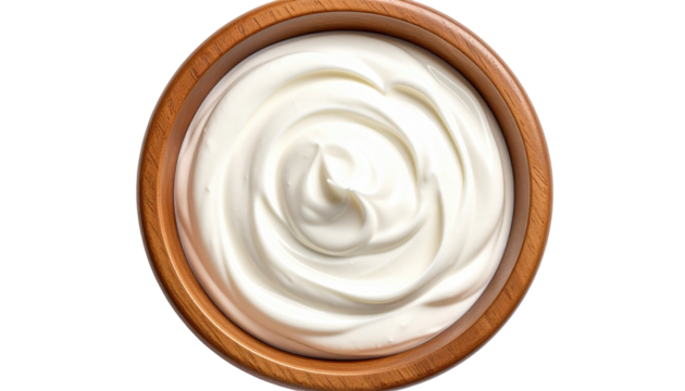 Overhead shot of a wooden bowl filled with creamy, white dairy product, swirling to create a pleasant spiral pattern