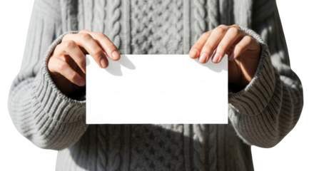 Person wearing gray cable knit sweater holding blank white card isolated on a transparent background