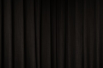 Close-up view of a black pleated curtain with subtle lighting	