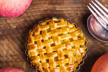 Delicious lattice top apple pie ready to serve on wooden table