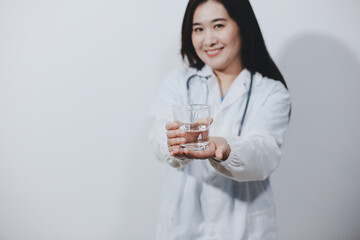 Portrait of Asian doctor woman standing holding coffee cup in white studio background