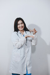 Portrait of Asian doctor woman standing holding coffee cup in white studio background