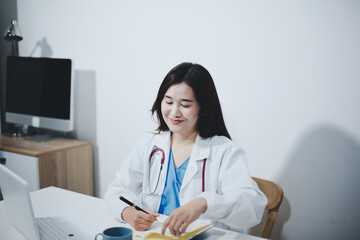 Middle aged female doctor working on laptop in doctor's room
