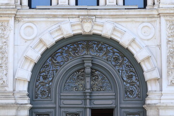 Building Facade Detail with Ornate Door Decoration and Stone Frame in Trieste, Italy