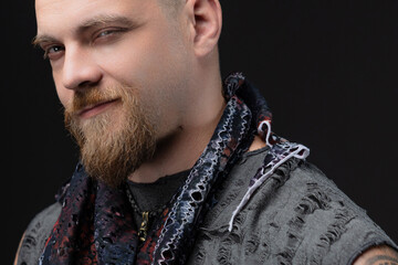 Charismatic bald man in street-style suit with handcuffs, studio portrait on gray