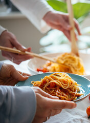 Friends having a pasta dinner with wine at home.