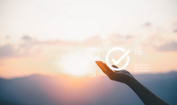 Businessman holding digital ISO icon with certification documents, symbolizing international standards, quality control assurance, compliance, regulation, auditing, and global business certification.