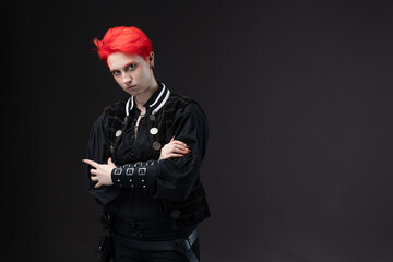 Young woman with bright red hair in vintage pirate suit on dark background