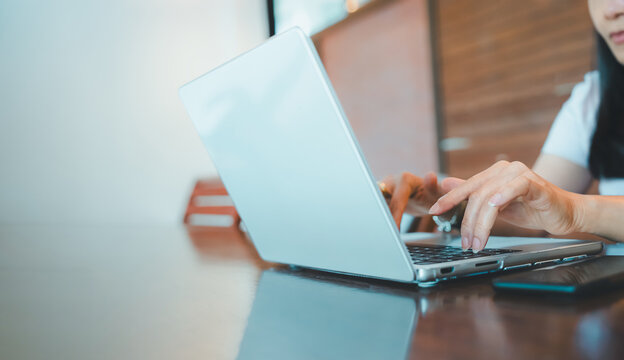 Business woman hands typing on laptop keyboard,smartphone on table at home office.Employee person hand using computer remote work,digital marketing online,connection,e-learning,freelance career - Powered by Adobe