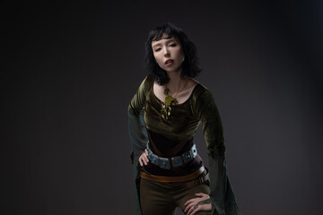 Forest elf warrior with short black hair, flowing fabric blouse and leather dagger belt.