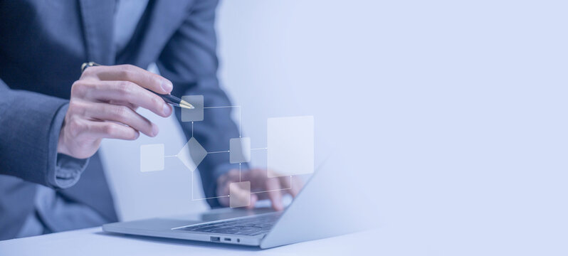 businessman working on a laptop with a digital workflow diagram, business process automation, and data flow. technology transformation concept. algorithm chart, flowchart automation, structure digital
